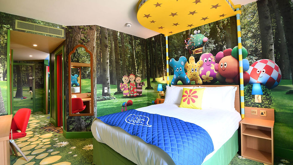 A colourful kids bedroom with wallpaper of a forest and cute characters.