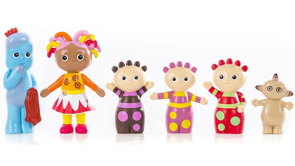 Six colourful toys in various shapes and colours, lined up next to each other in front of a white wall.