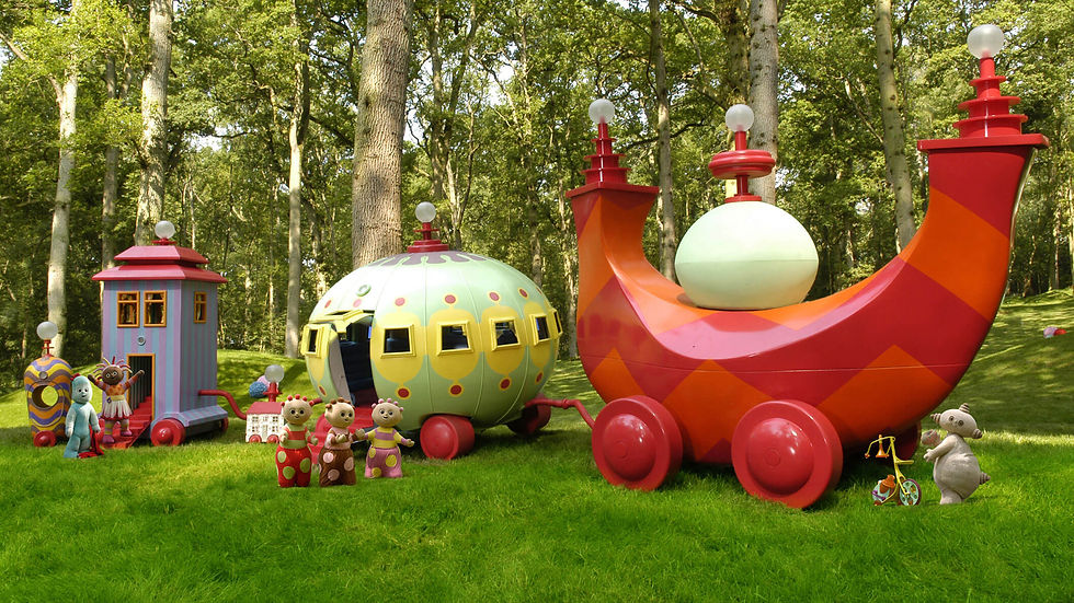 a train with a red and orange engine pulling a green and yellow car, a little house car, a big house car and a round caboose.