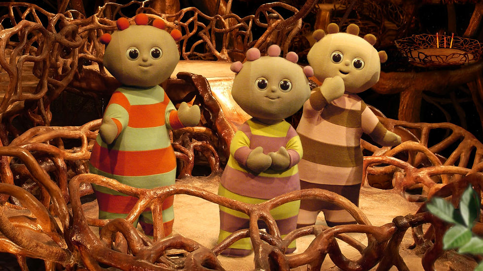Three cute characters, with round heads and striped pyjamas, standing inside a brown, wicker basket,