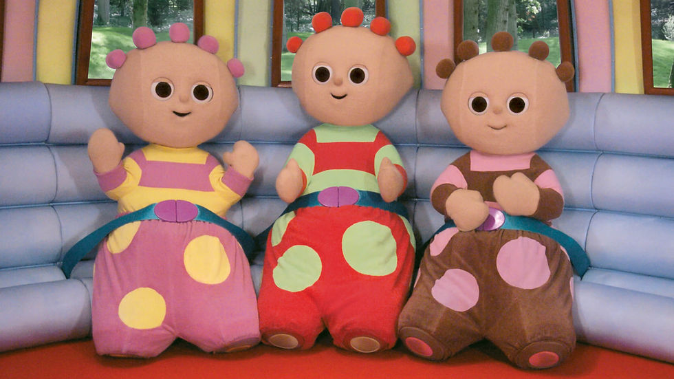 Three cute characters, wearing colourful clothes with polka dots, standing on a red floor and leaning on a blue wall.